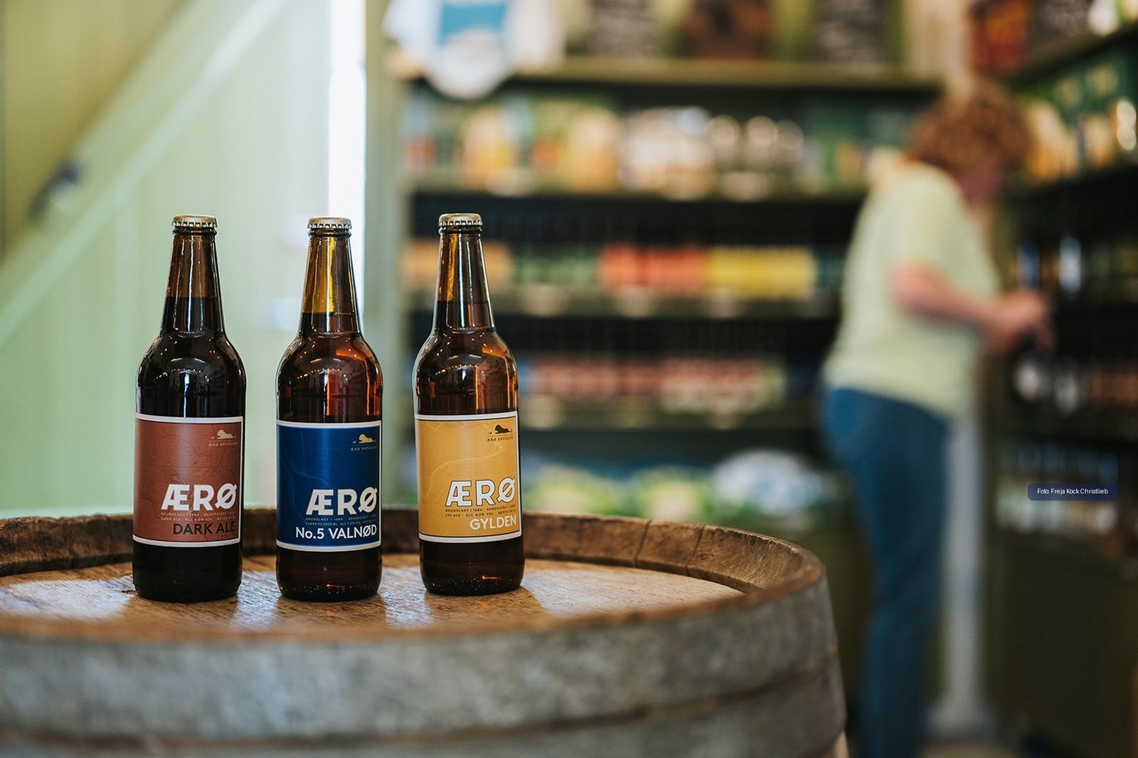 Regionales &AElig;r&oslash;-Bier auf einem Holzfass in einem Inselladen