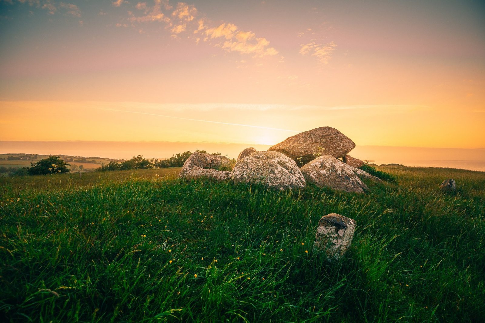 Gro&szlig;e Steine auf einer Wiese auf &AElig;r&oslash; bei Sonnenuntergang