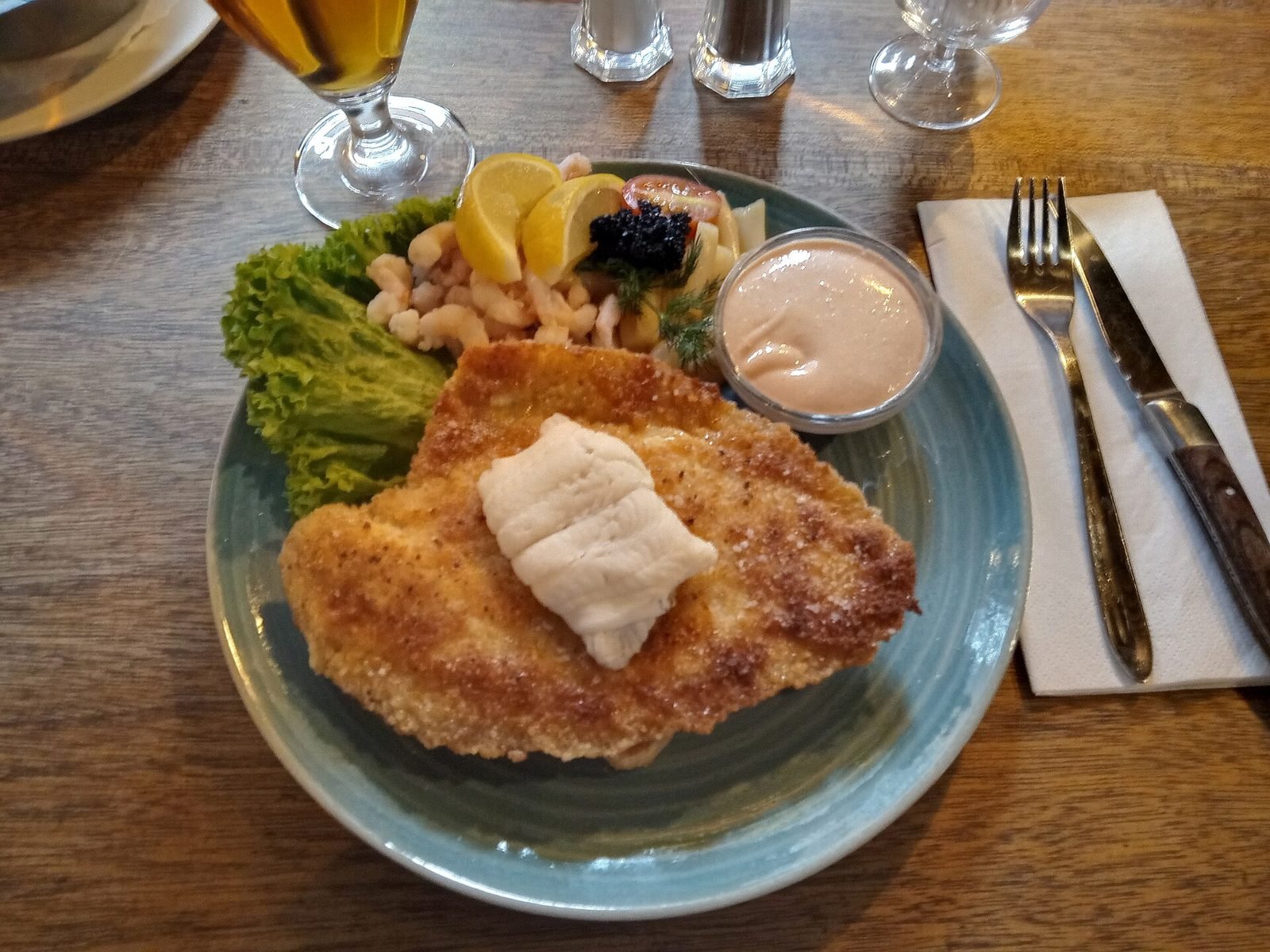 Stjerneskud auf einem Teller: gebratenes Schollenfilet mit Krabben, Salat, Zitrone und Rogen auf ger&ouml;stetem Brot